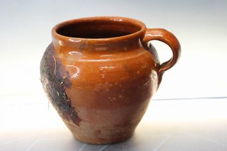 Pequeña y antigua olla de barro.