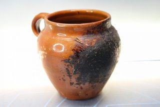 Pequeña y antigua olla de barro.