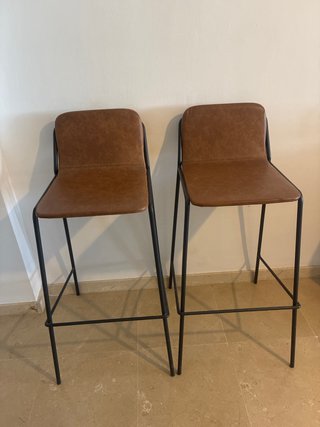 Dos taburetes altos de cuero y metal