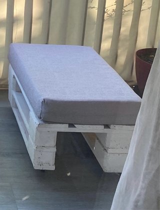 Sofá y asiento de palets con cojines.