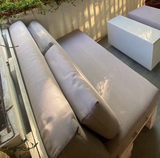 Sofá y asiento de palets con cojines.