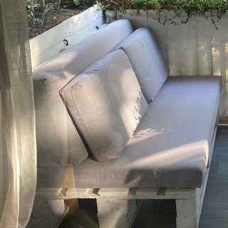Sofá y asiento de palets con cojines.