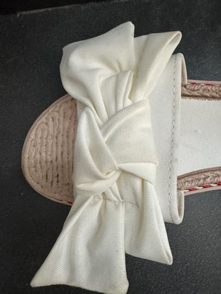 Chanclas planas blancas y beige.