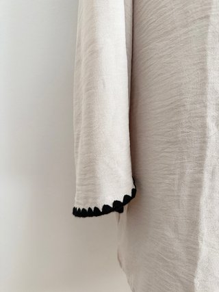 Blusa beige con ribete negro