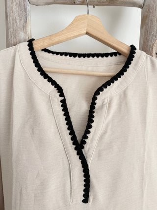 Blusa beige con ribete negro