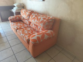 Sofá naranja y blanco con estampado floral