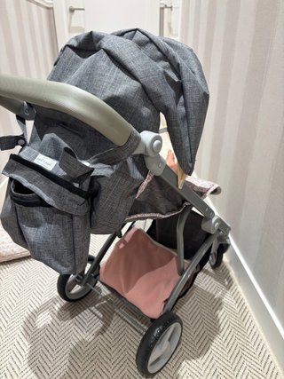 Carrito de muñecas gris con estampado floral.
