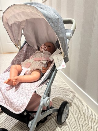 Carrito de muñecas gris con estampado floral.