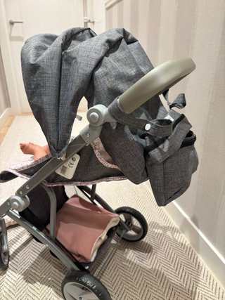 Carrito de muñecas gris con estampado floral.