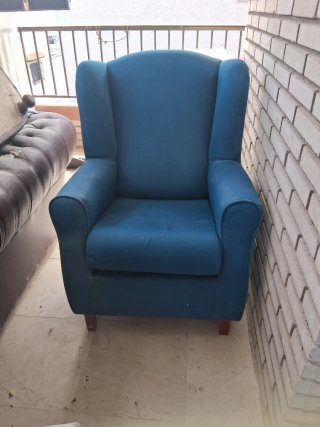 Sillón azul de tela en persoma a negociar