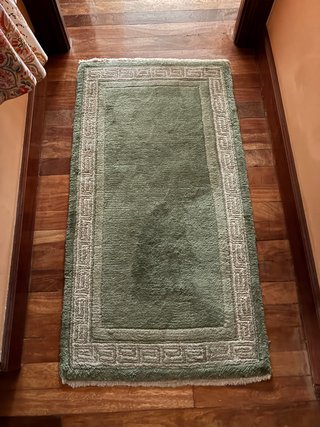 Alfombra verde con borde decorativo