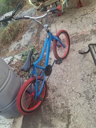 Bicicleta BMX azul con ruedas rojas