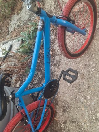 Bicicleta BMX azul con ruedas rojas
