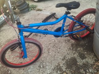 Bicicleta BMX azul con ruedas rojas