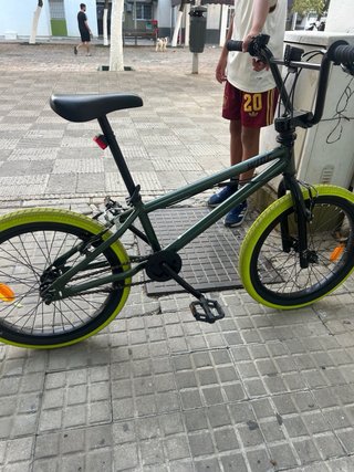 Bicicleta infantil verde con ruedas amarillas