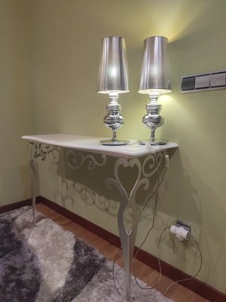 Mueble de entrada plateado con lámparas