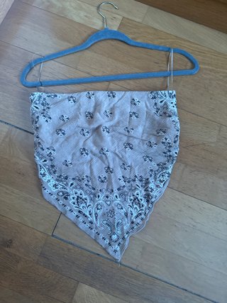 Top bandolera beige con flores negras