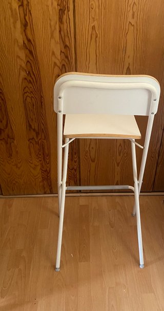 Silla alta plegable blanca.