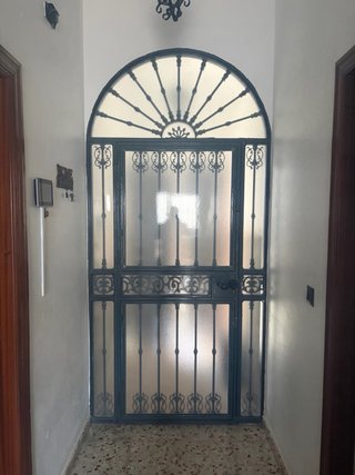 Portón de entrada con arco y rejas
