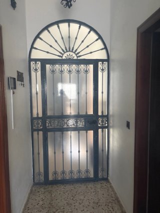 Portón de entrada con arco y rejas