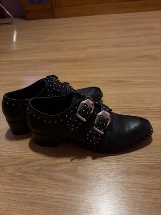 Zapatos negros con tachuelas y hebillas