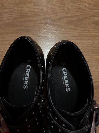 Zapatos negros con tachuelas y hebillas