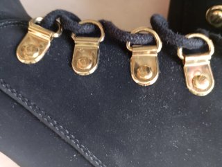 Botines negros ante ojales dorados