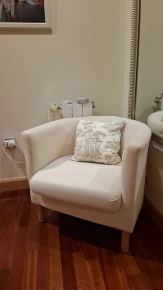 Sillón de tela beige con cojín