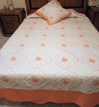 Colcha y cojín naranja y blanco