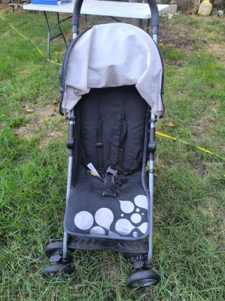 Silla de paseo negra con lunares blancos.