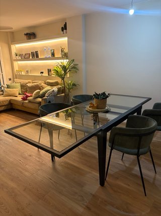Mesa de comedor de cristal extensible.