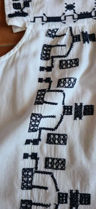 Camisa blanca con bordados en color azul marino.
