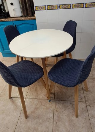 Mesa redonda blanca con 4 sillas patchwork.