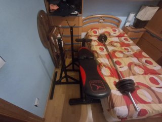 Banco de musculación con barra y pesas