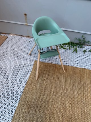 Trona Stokke verde con patas de madera y bandeja