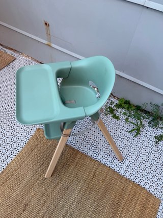 Trona Stokke verde con patas de madera y bandeja