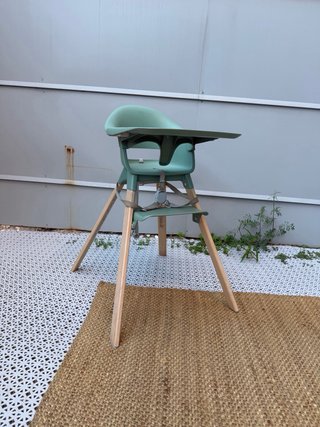 Trona Stokke verde con patas de madera y bandeja