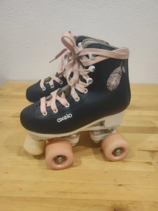 Patines Oxelo azules con cordones y ruedas rosas.