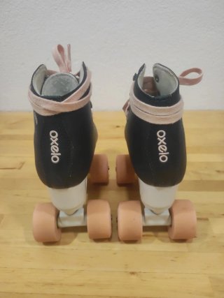Patines Oxelo azules con cordones y ruedas rosas.