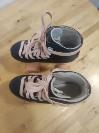 Patines Oxelo azules con cordones y ruedas rosas.