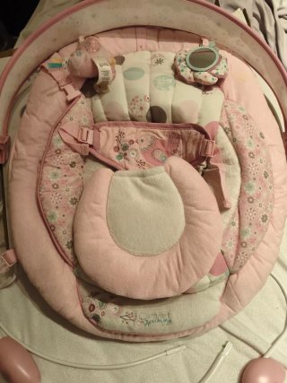 Columpio para bebé rosa con juguetes