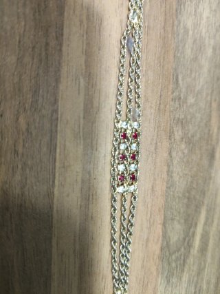 Pulsera antigua chapada en oro con detalles rojos
