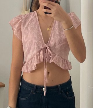 Top rosa con volantes y lazada