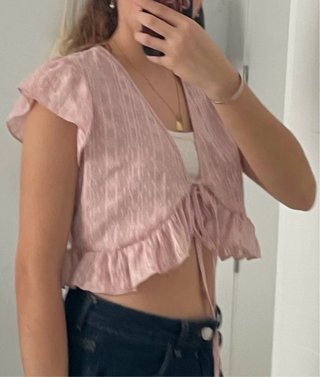 Top rosa con volantes y lazada