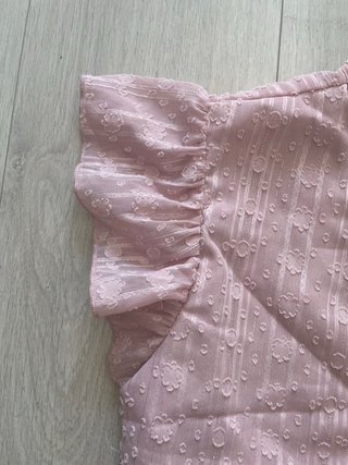 Top rosa con volantes y lazada