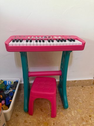 Piano de juguete rosa con taburete