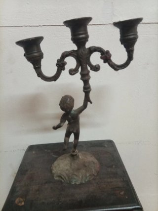 Candelabro antiguo de metal con figura