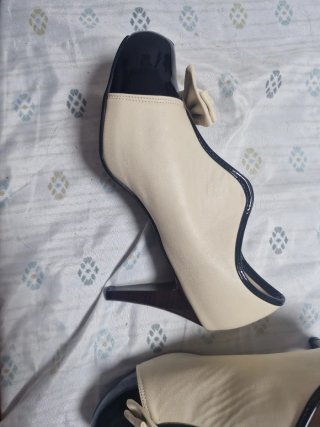 Zapatos de tacón beige y negro con lazo