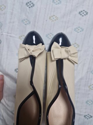 Zapatos de tacón beige y negro con lazo