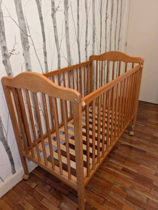 Cuna de madera para bebé con ositos grabados.